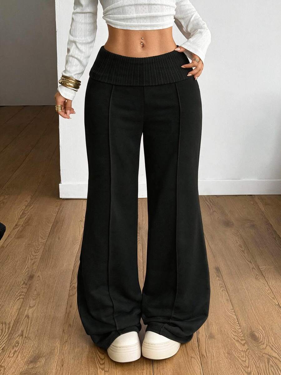 Women's wide leg flare sweatpants featuring a black and white colorblock contrast fold waistband and side stripe details.