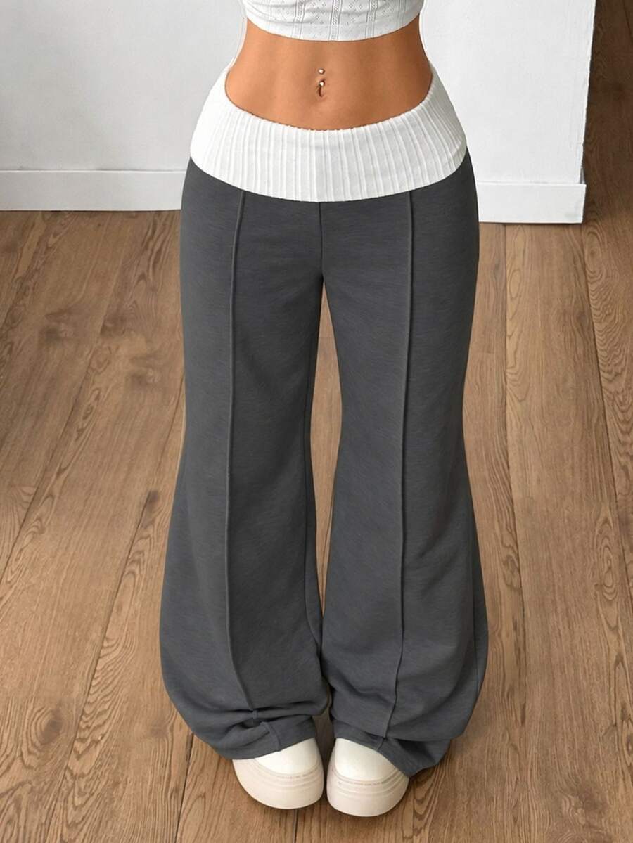 Women's wide leg flare sweatpants featuring a black and white colorblock contrast fold waistband and side stripe details.