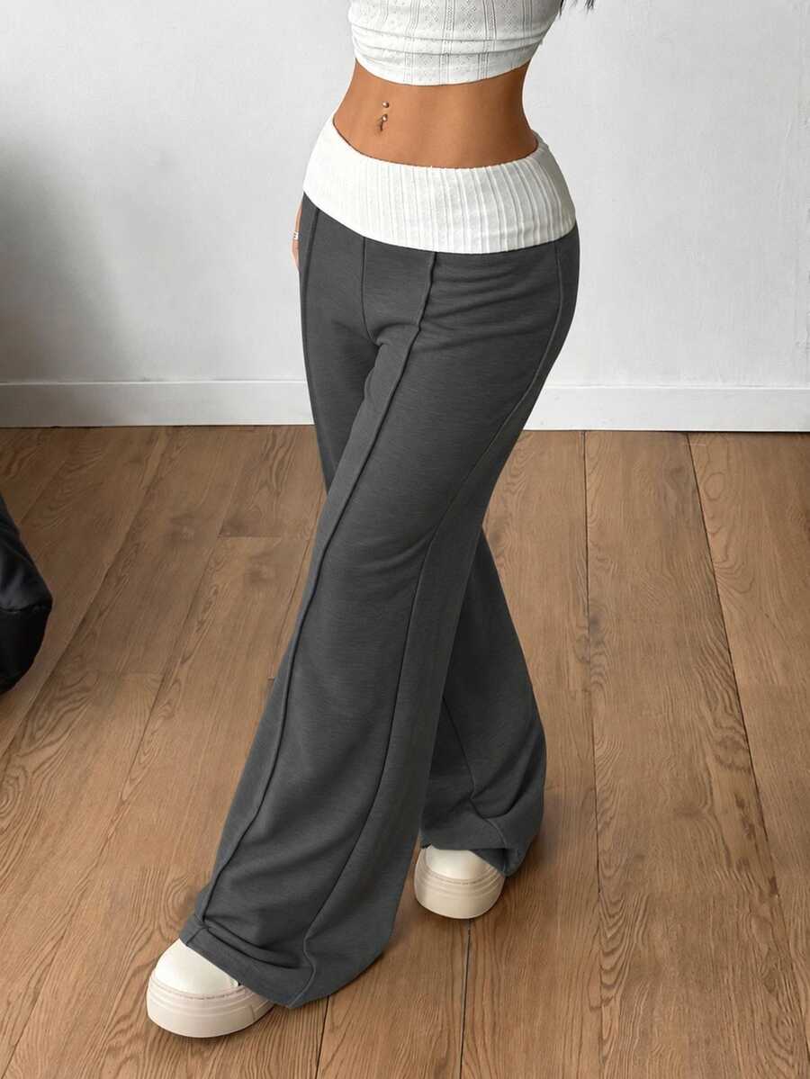 Women's wide leg flare sweatpants featuring a black and white colorblock contrast fold waistband and side stripe details.