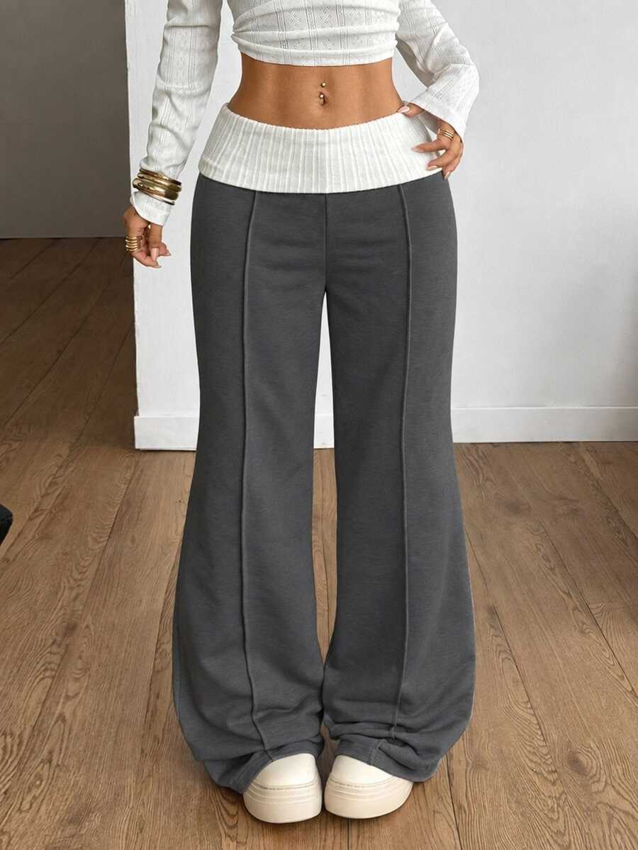 Women's wide leg flare sweatpants featuring a black and white colorblock contrast fold waistband and side stripe details.