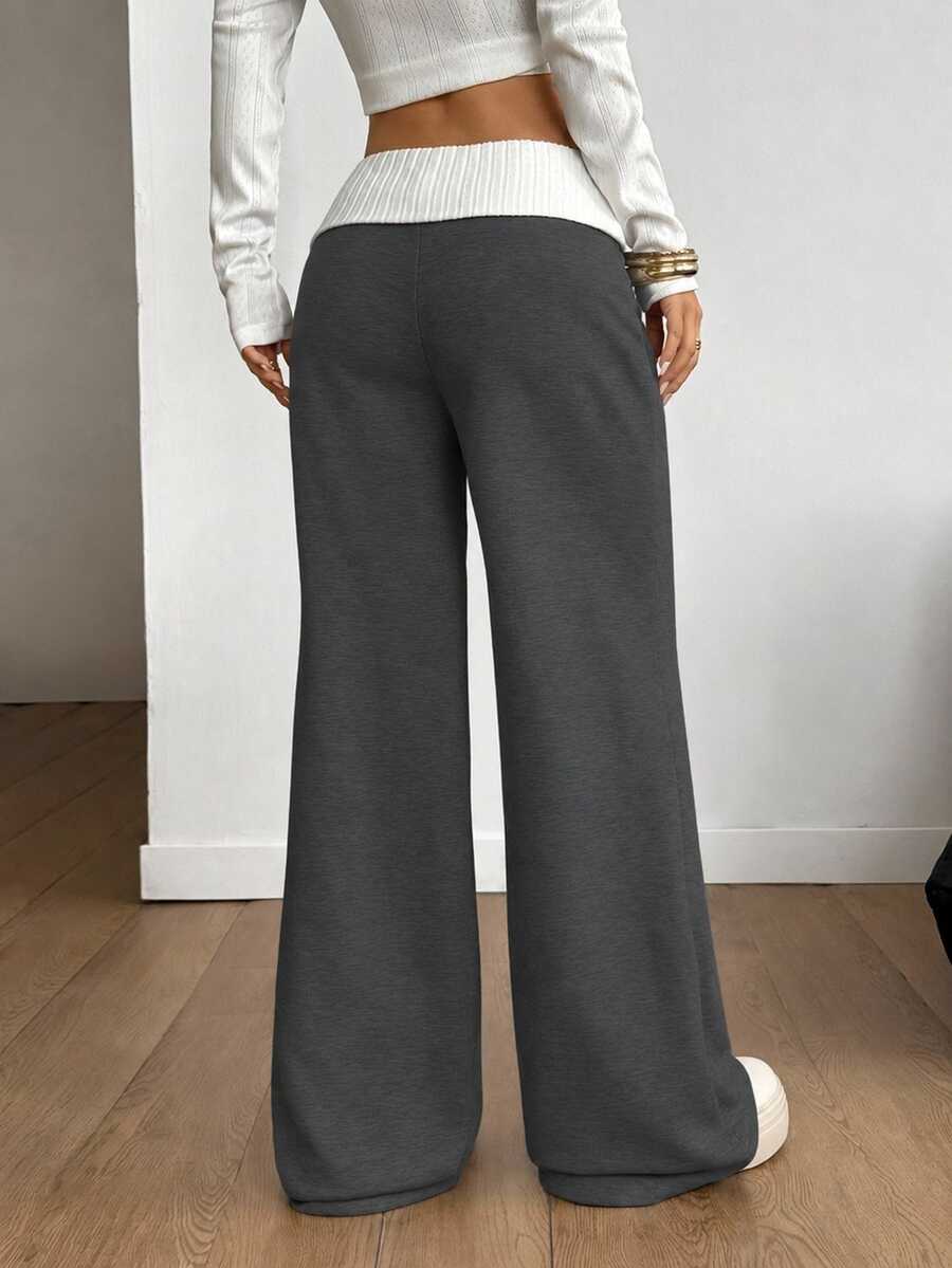 Women's wide leg flare sweatpants featuring a black and white colorblock contrast fold waistband and side stripe details.