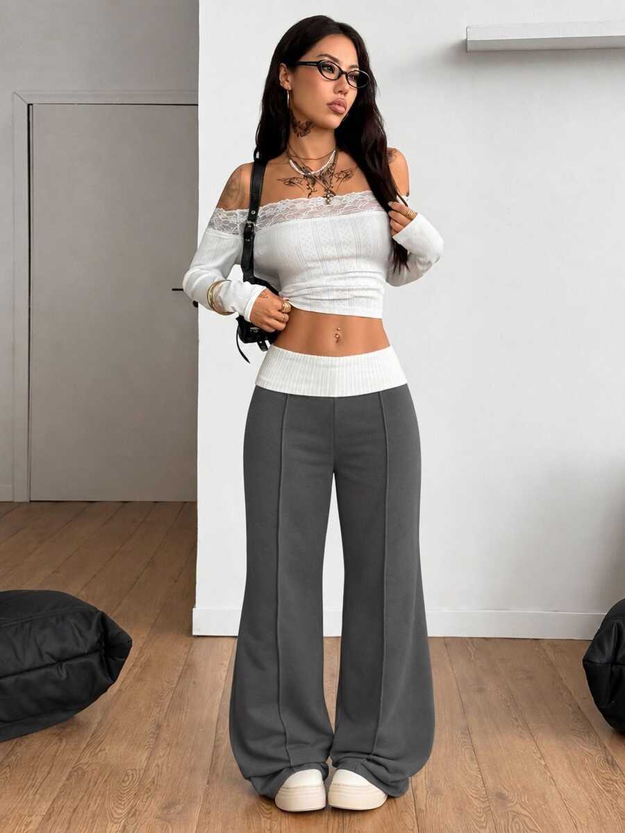 Women's wide leg flare sweatpants featuring a black and white colorblock contrast fold waistband and side stripe details.