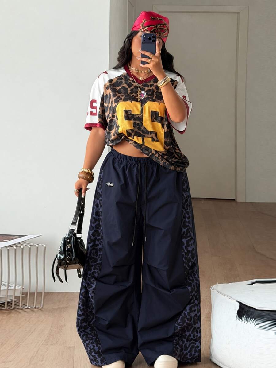 Women's high waist wide leg pants in black featuring leopard print patchwork details and an elastic drawstring waistband.