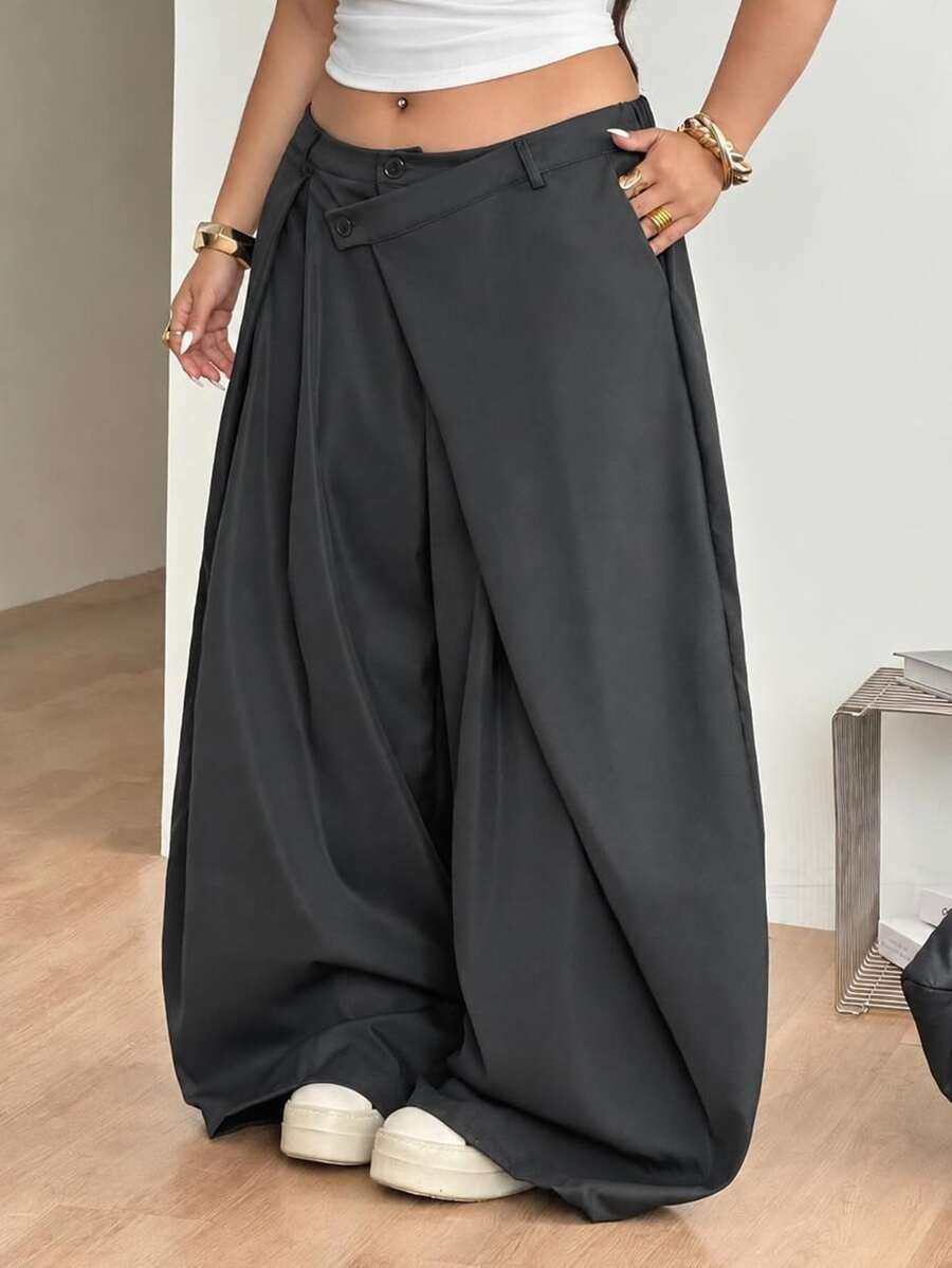 Front view of women's loose curved banana pants featuring a mid waist, side pockets, and asymmetrical plicated hem.