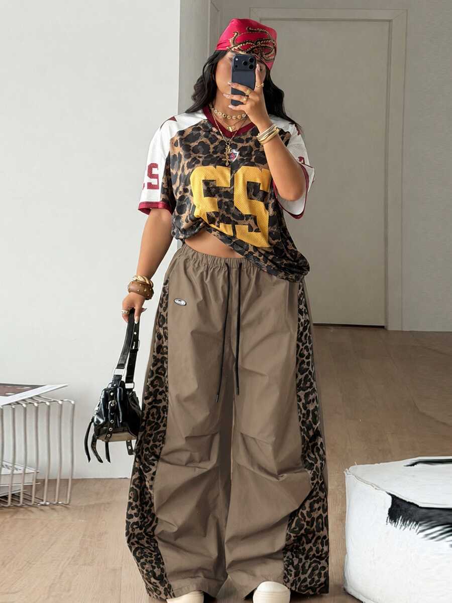 Women's high waist wide leg pants in black featuring leopard print patchwork details and an elastic drawstring waistband.