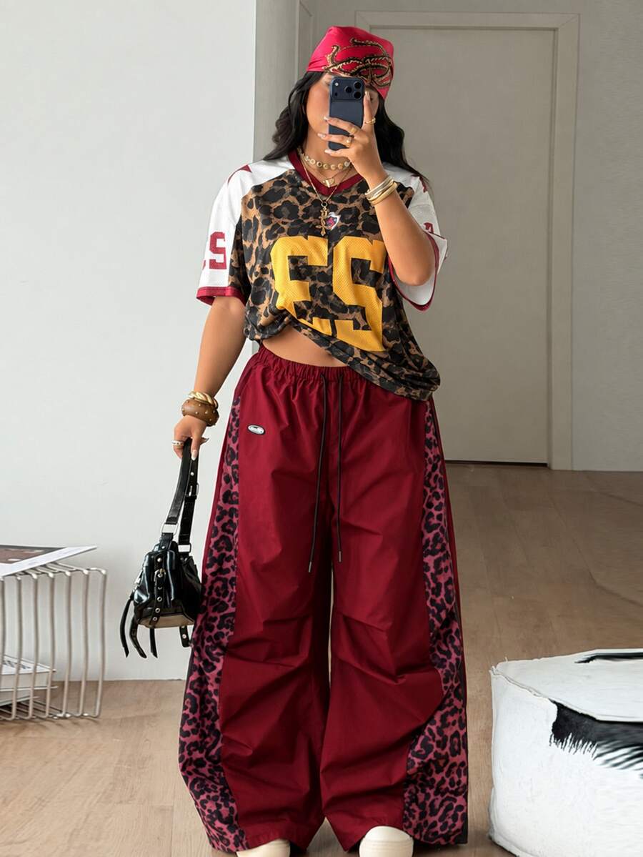 Women's high waist wide leg pants in black featuring leopard print patchwork details and an elastic drawstring waistband.