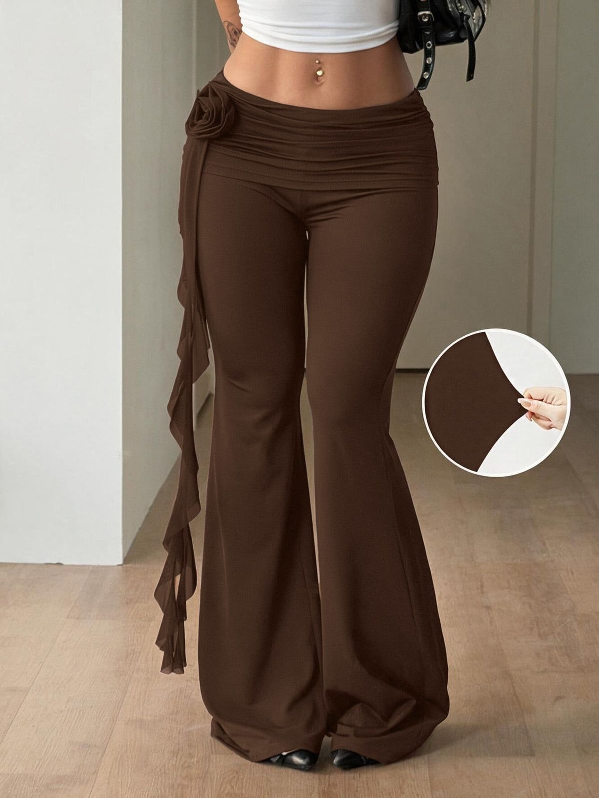 Black low waist flare pants featuring 3D rose and side stripe detailing in stretchy mesh fabric.