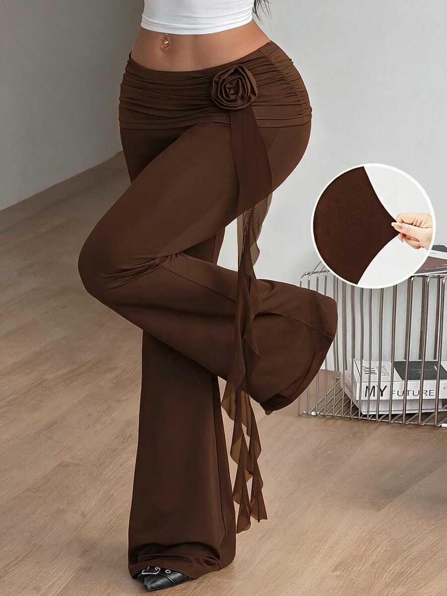 Black low waist flare pants featuring 3D rose and side stripe detailing in stretchy mesh fabric.