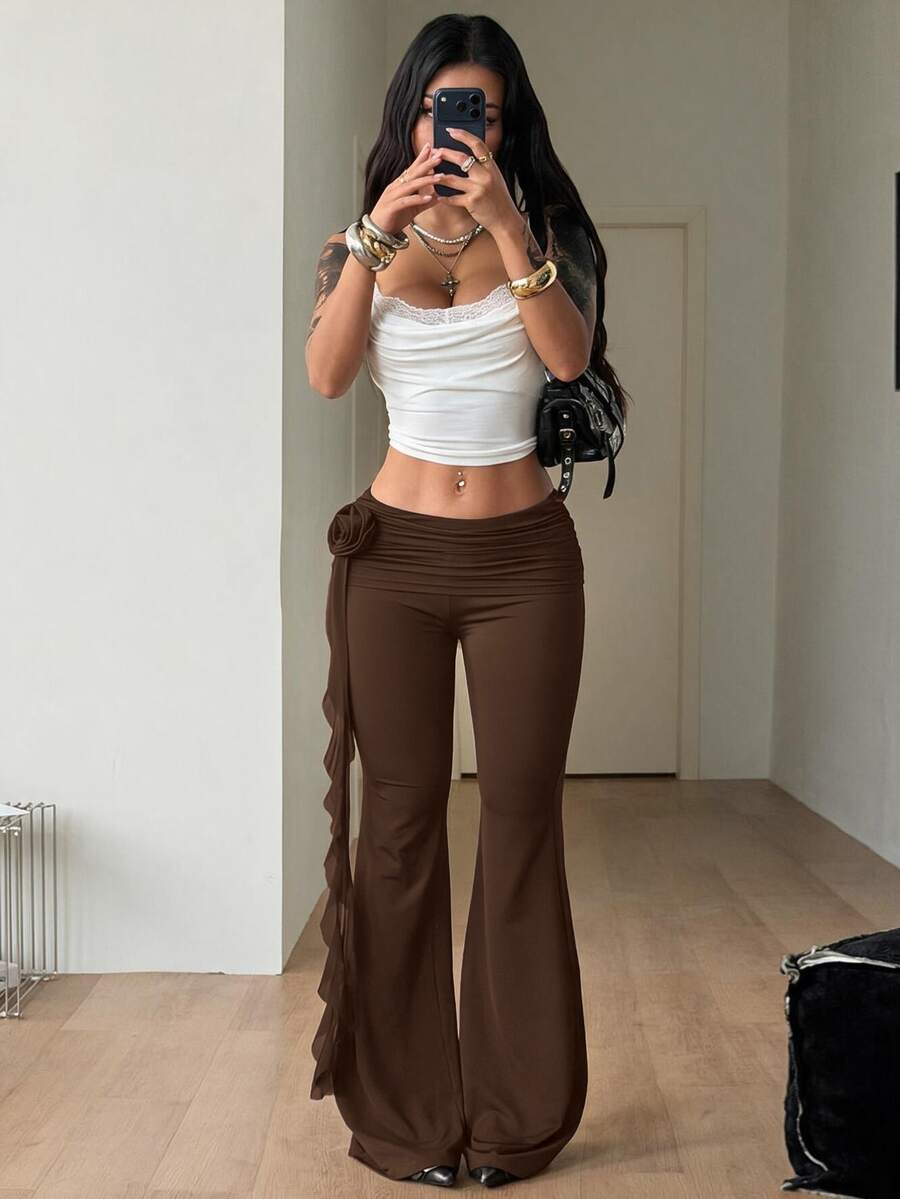 Black low waist flare pants featuring 3D rose and side stripe detailing in stretchy mesh fabric.