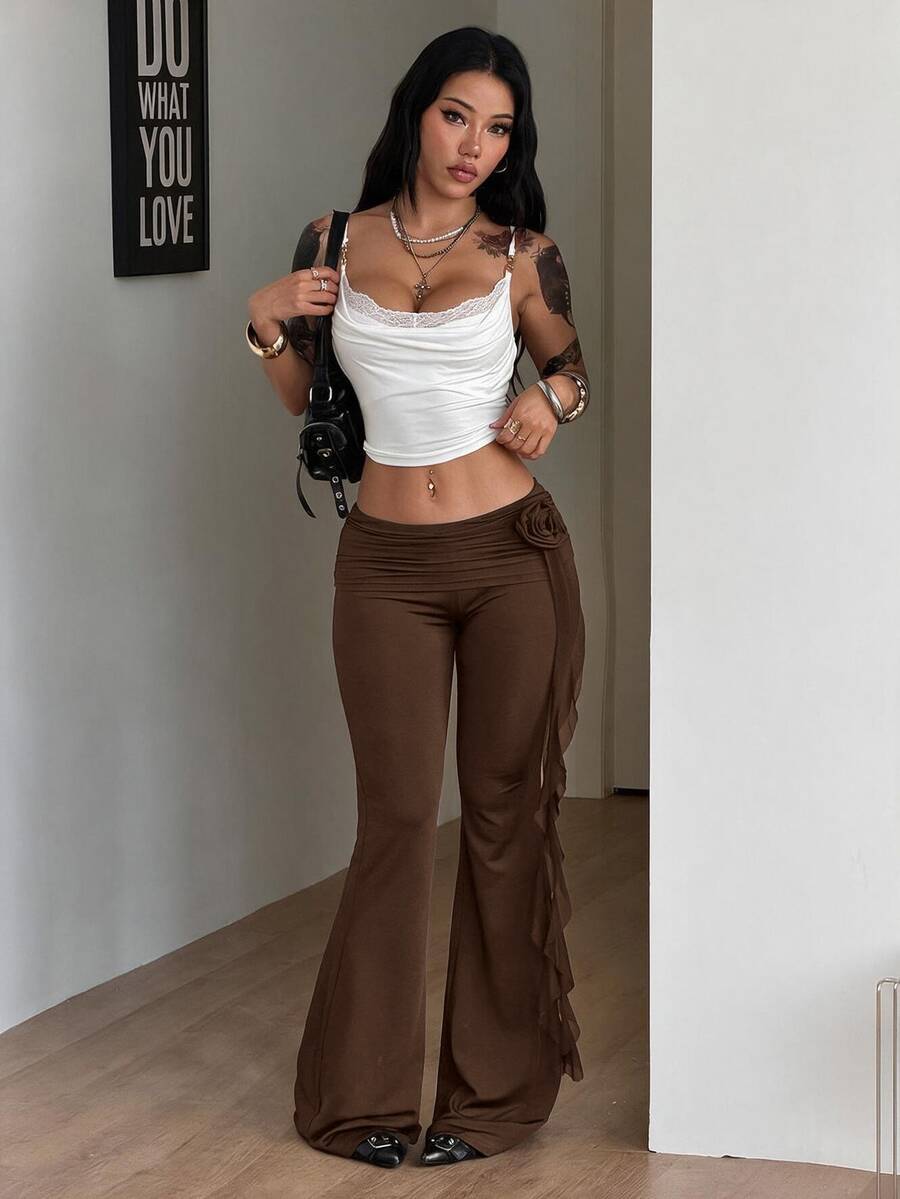 Black low waist flare pants featuring 3D rose and side stripe detailing in stretchy mesh fabric.