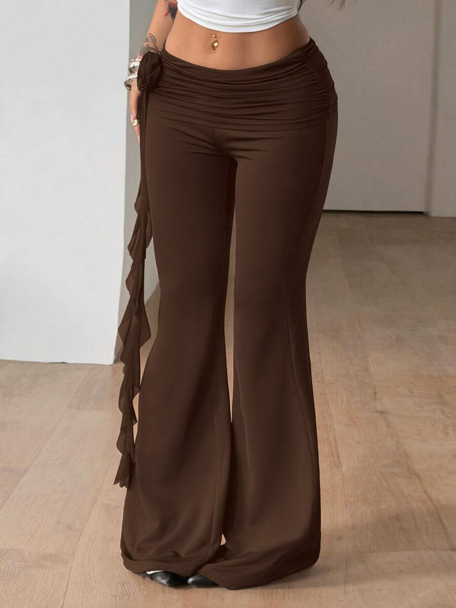 Black low waist flare pants featuring 3D rose and side stripe detailing in stretchy mesh fabric.