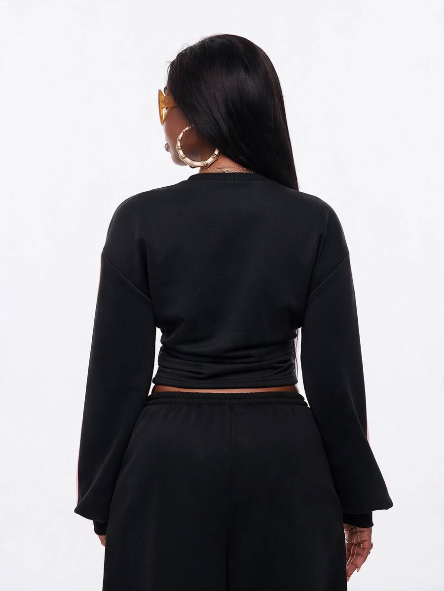 Women's casual black long sleeve knitted pullover sweatshirt featuring a round neck and cinched waist design.