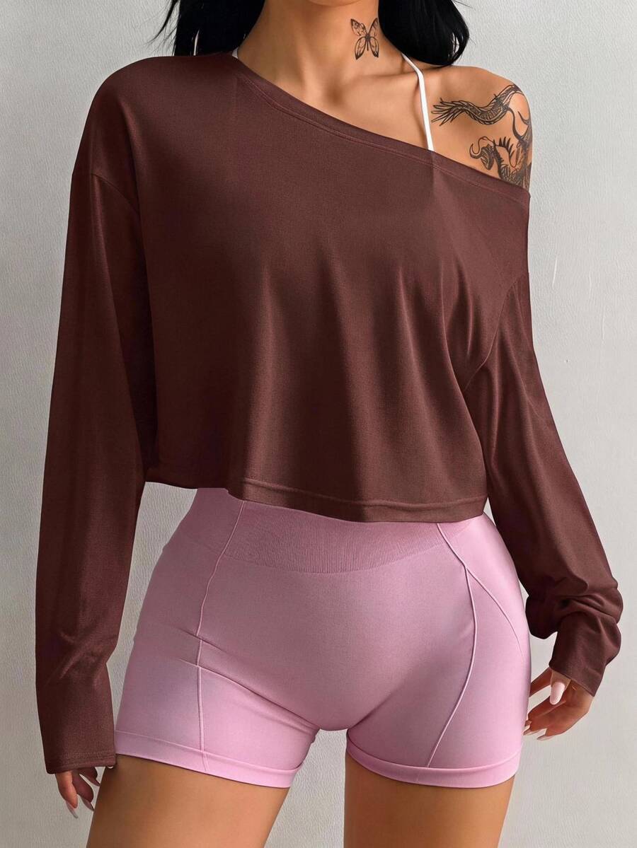 Women's white one shoulder rib-knit crop pullover top featuring an asymmetrical neckline, drop shoulder long sleeves, and a relaxed loose fit for yoga and athleisure wear.