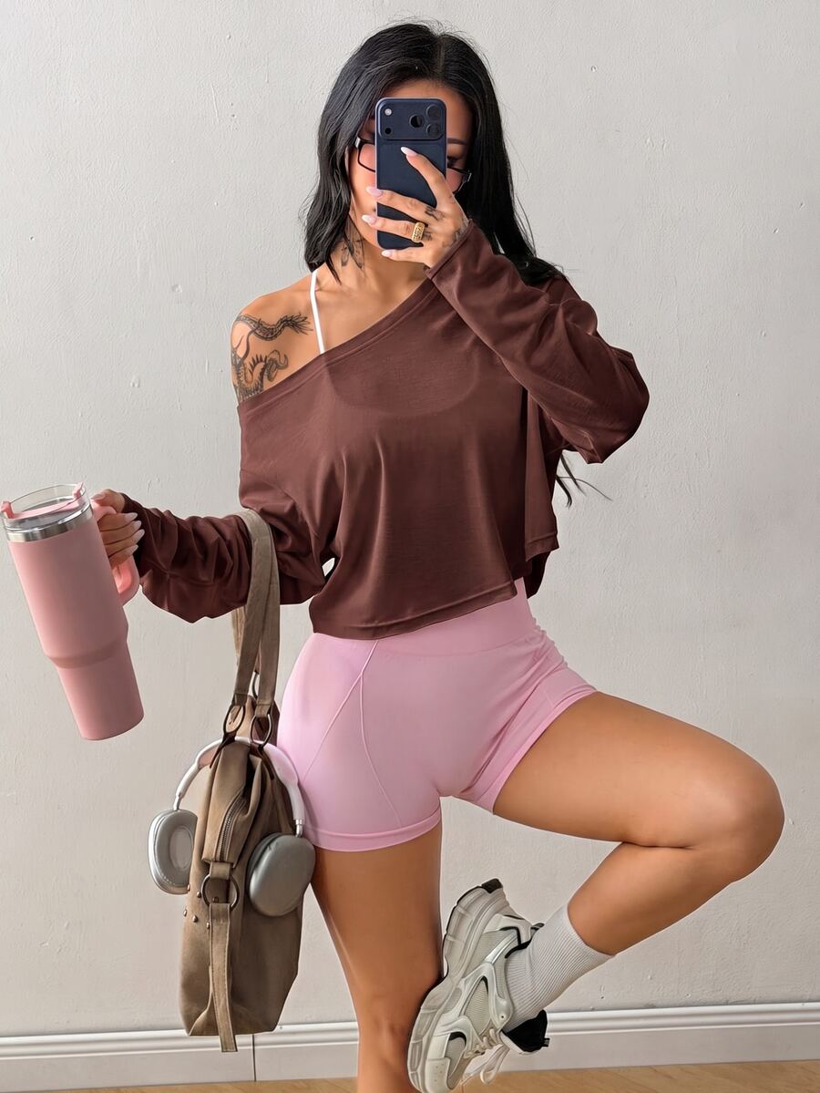 Women's white one shoulder rib-knit crop pullover top featuring an asymmetrical neckline, drop shoulder long sleeves, and a relaxed loose fit for yoga and athleisure wear.