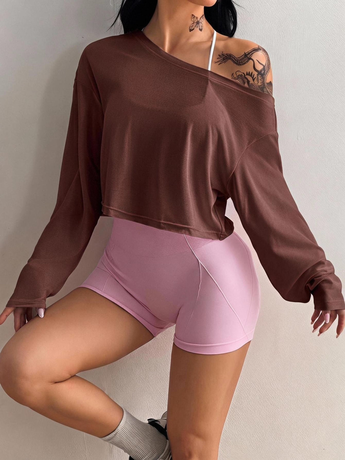 Women's white one shoulder rib-knit crop pullover top featuring an asymmetrical neckline, drop shoulder long sleeves, and a relaxed loose fit for yoga and athleisure wear.