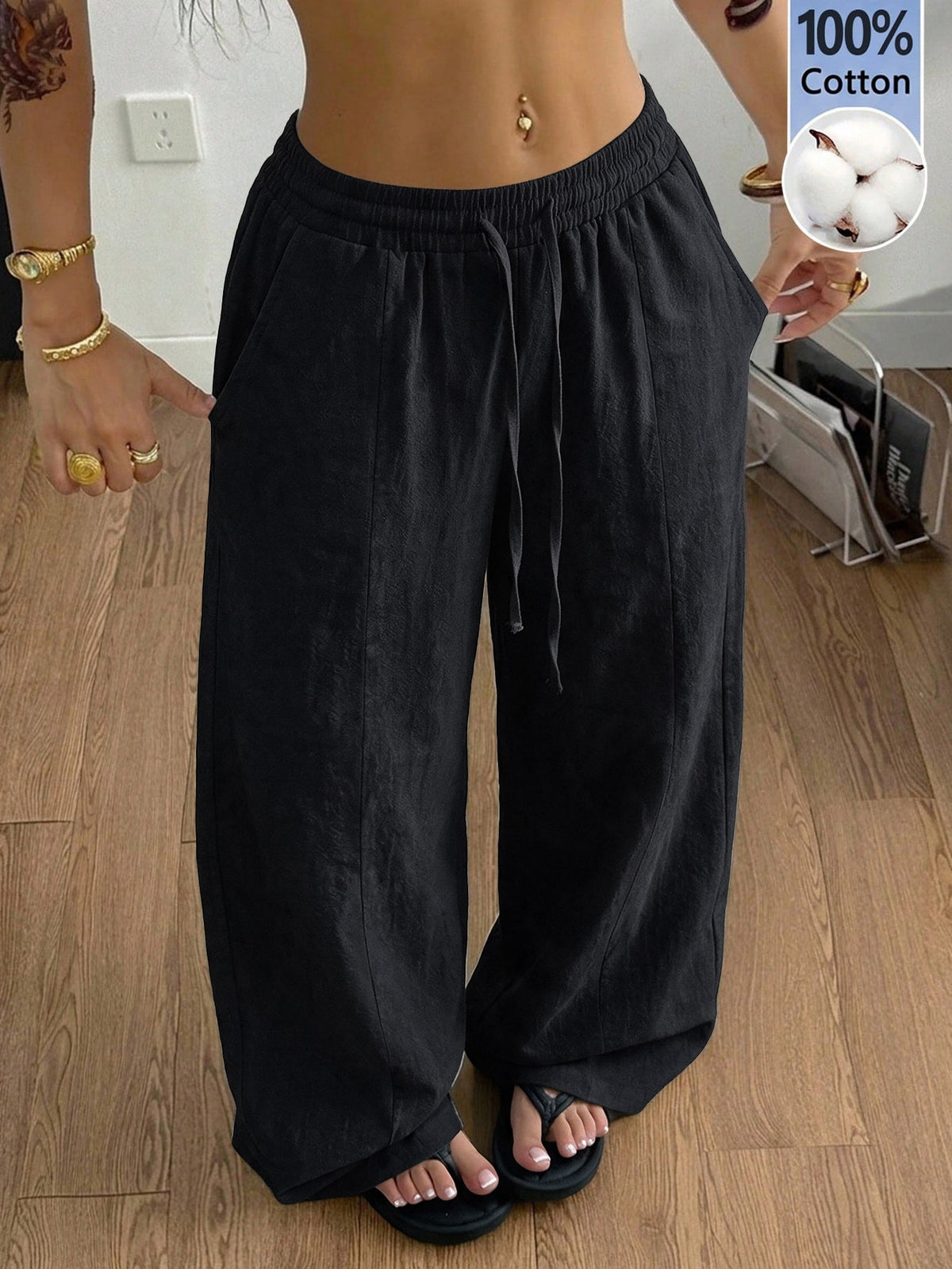 Women's loose straight leg cotton pants featuring a high waist with an adjustable drawstring knot and functional side pockets.