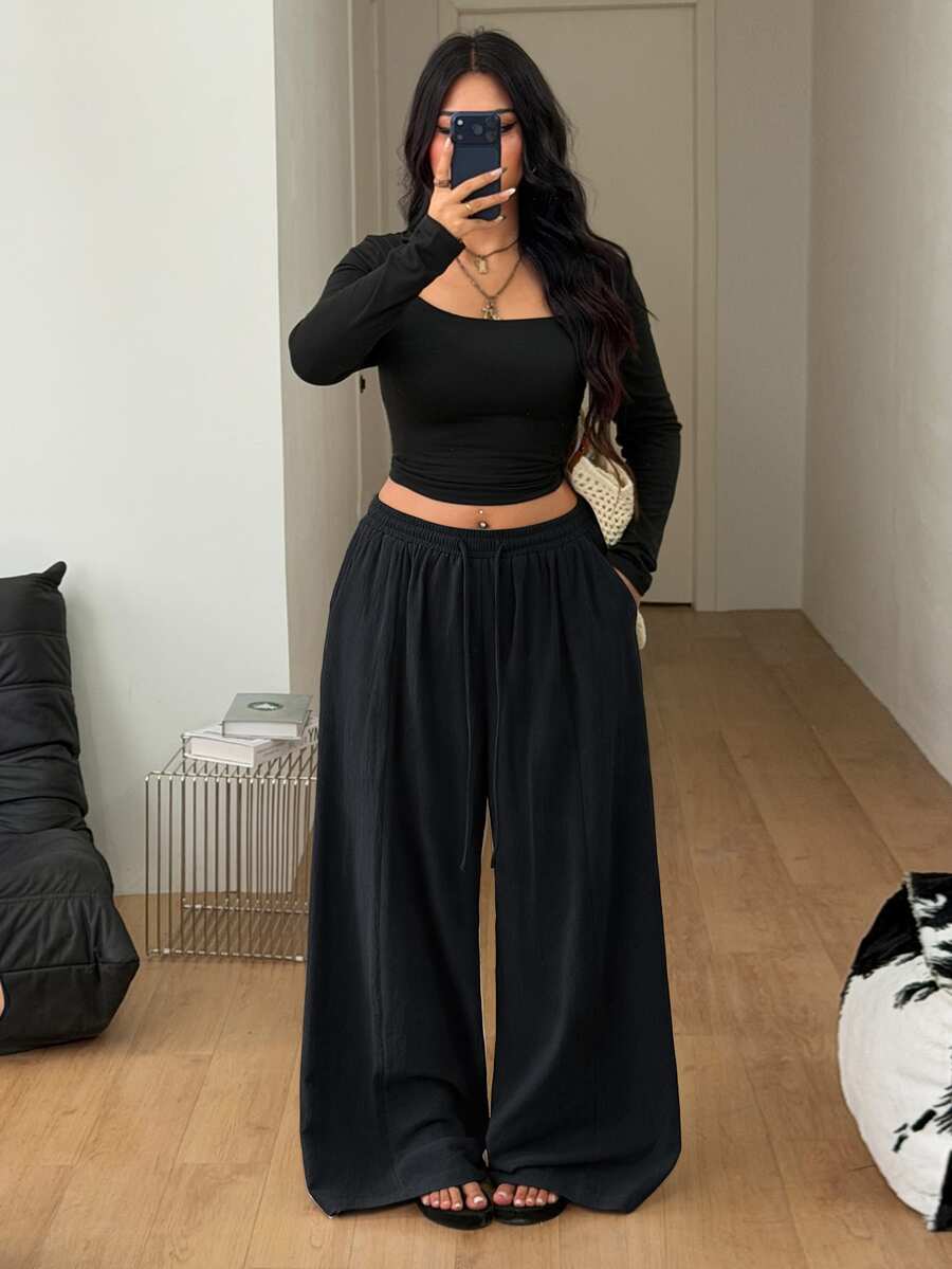 Women's loose straight leg cotton pants featuring a high waist with an adjustable drawstring knot and functional side pockets.