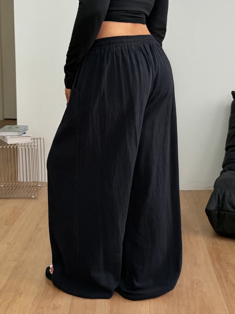 Women's loose straight leg cotton pants featuring a high waist with an adjustable drawstring knot and functional side pockets.