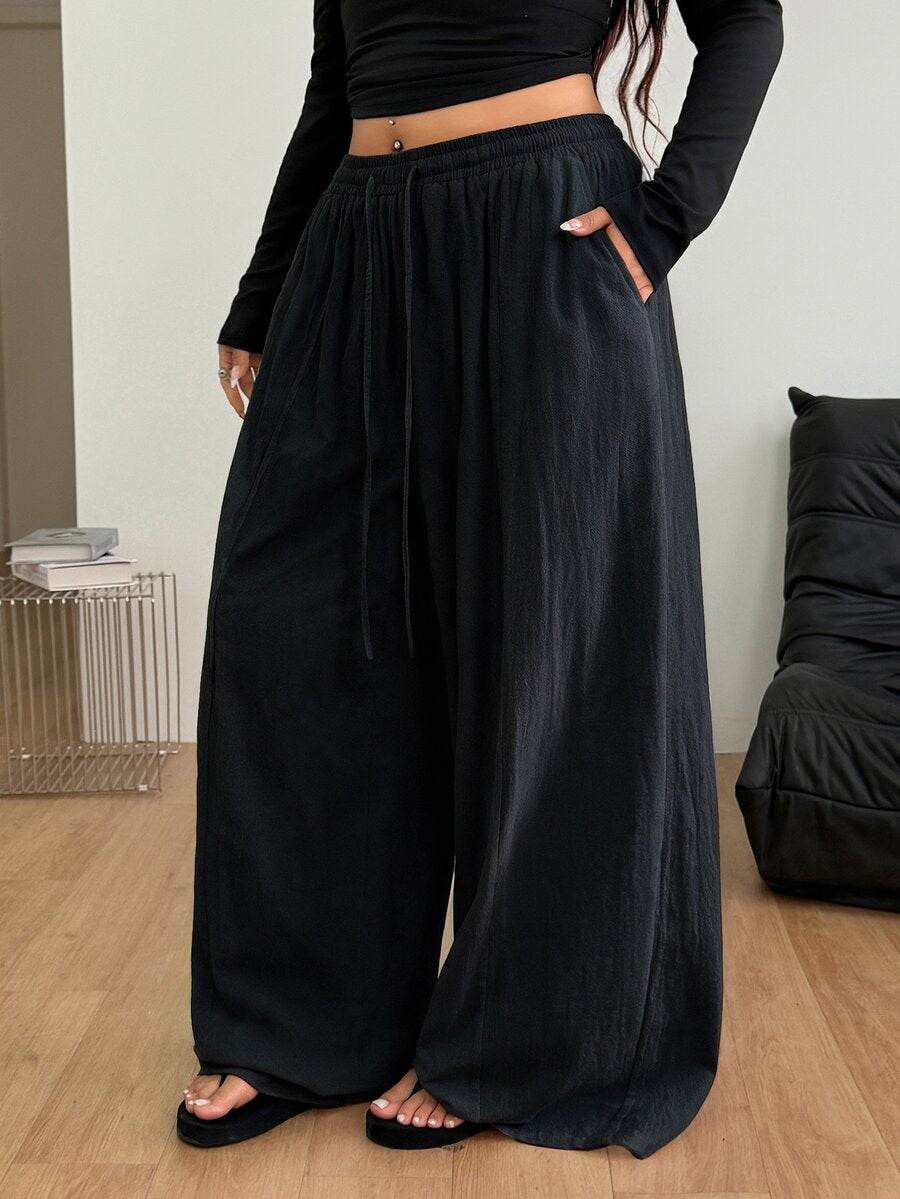 Women's loose straight leg cotton pants featuring a high waist with an adjustable drawstring knot and functional side pockets.