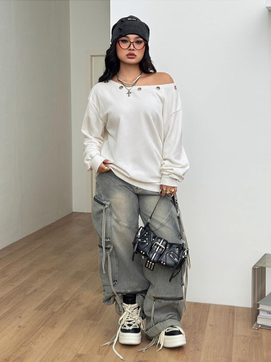 Women's oversized dark grey long sleeve sweatshirt featuring an asymmetrical boat neckline with grommet eyelet details and drop shoulders.