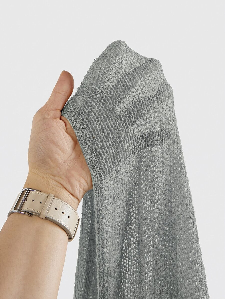 Women's casual hollow knit poncho top with boat neck, cloak sleeves, and asymmetrical hem