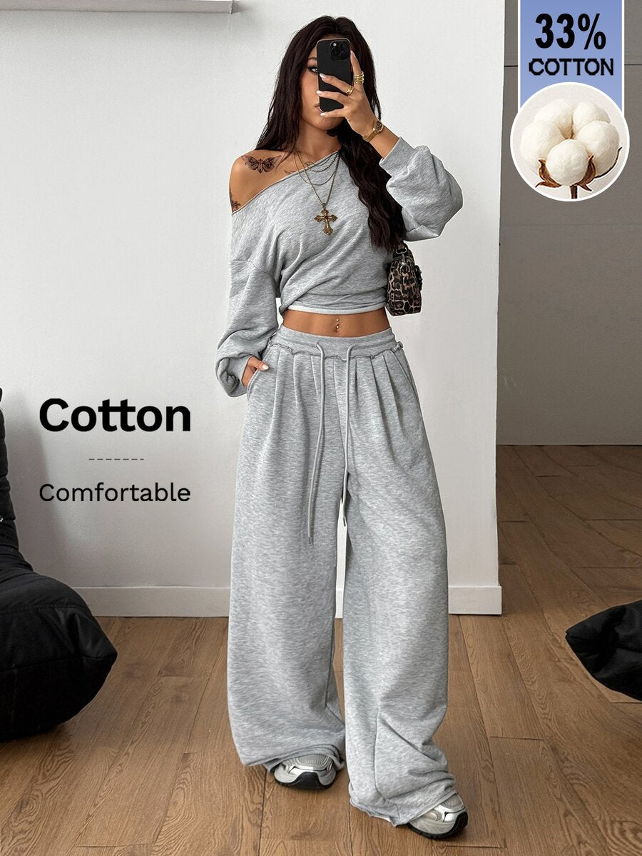 Women's two-piece casual lounge set featuring a loose drop-shoulder long sleeve sweatshirt and high-waist drawstring sweatpants with pockets.