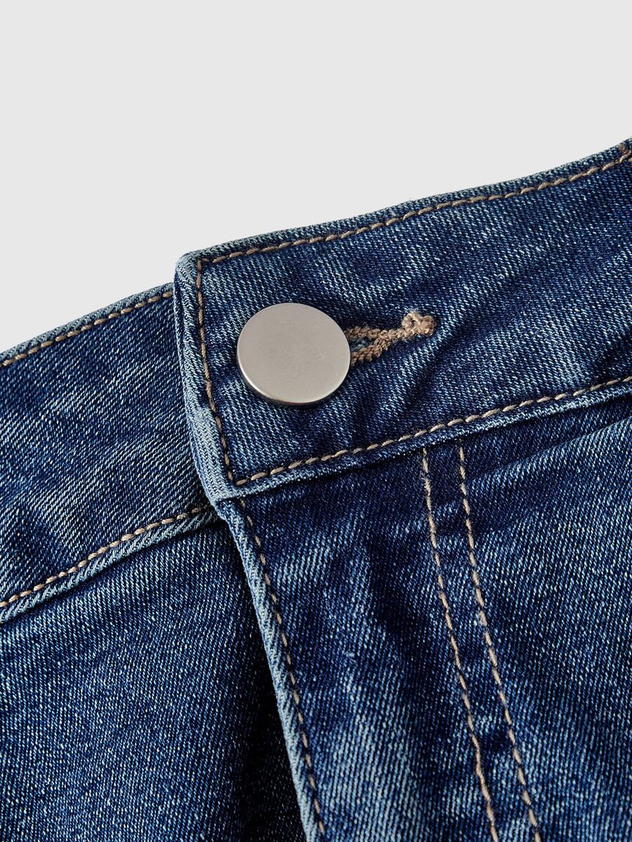 Front view of a women's plus size denim mini skirt with contrast lace trim and a fitted silhouette.