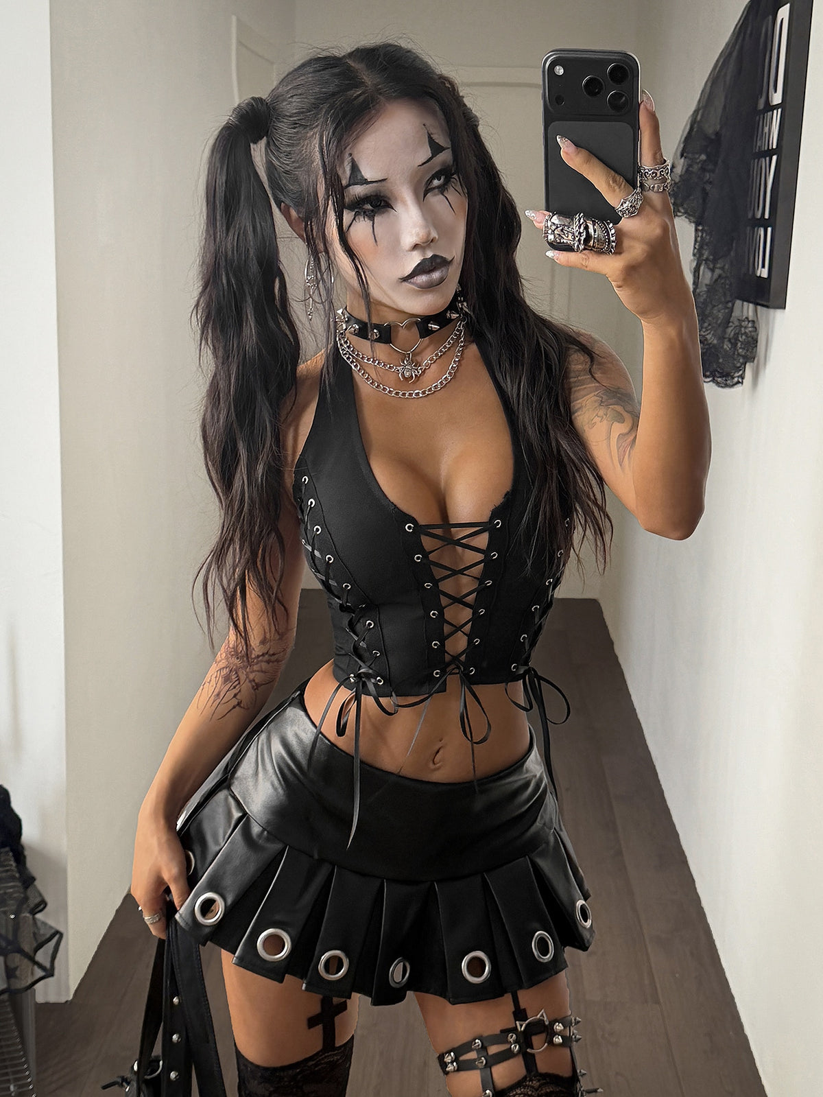 Black woven halter corset crop top for women featuring front lace-up detailing with grommet eyelets and an asymmetrical hem.