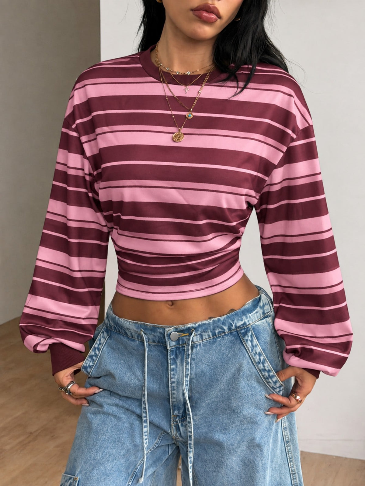 Women's striped pullover sweatshirt featuring drop shoulder long sleeves and a classic round neckline.