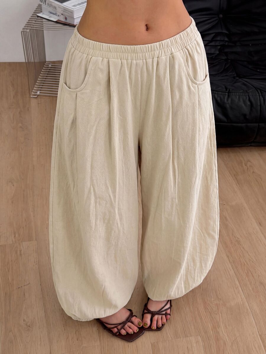 Women's loose-fit black bloomer pants made of 100% cotton featuring an elastic waistband and side pockets.