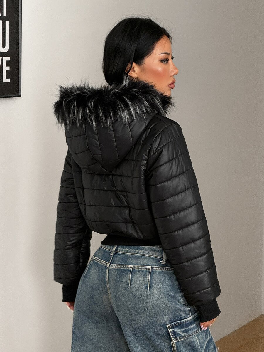Women's brown cropped puffer jacket featuring a faux fur trimmed hood, front zipper, and ribbed hem.