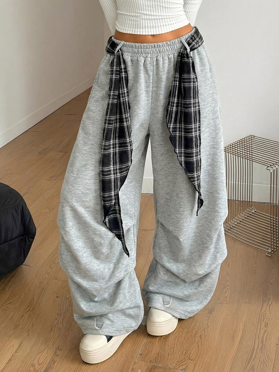 Loose-fitting black baggy parachute pants featuring an elastic drawstring waistband and wide-leg cut made from cotton blend fabric.