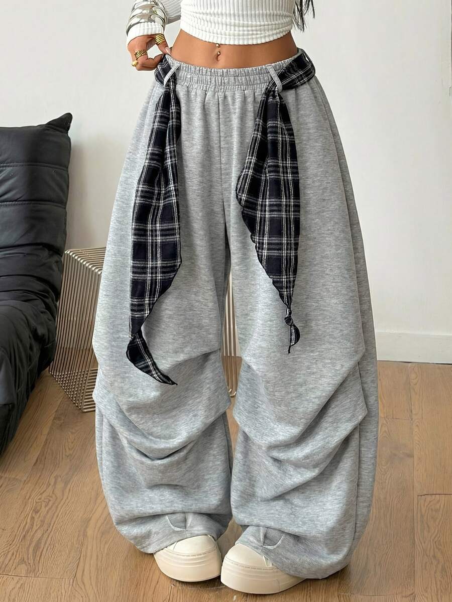 Loose-fitting black baggy parachute pants featuring an elastic drawstring waistband and wide-leg cut made from cotton blend fabric.