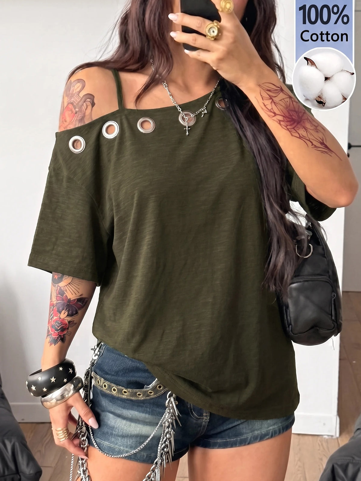 Women's loose-fit black cotton oversized t-shirt featuring an asymmetrical cold shoulder cutout neckline and short drop-shoulder sleeves.