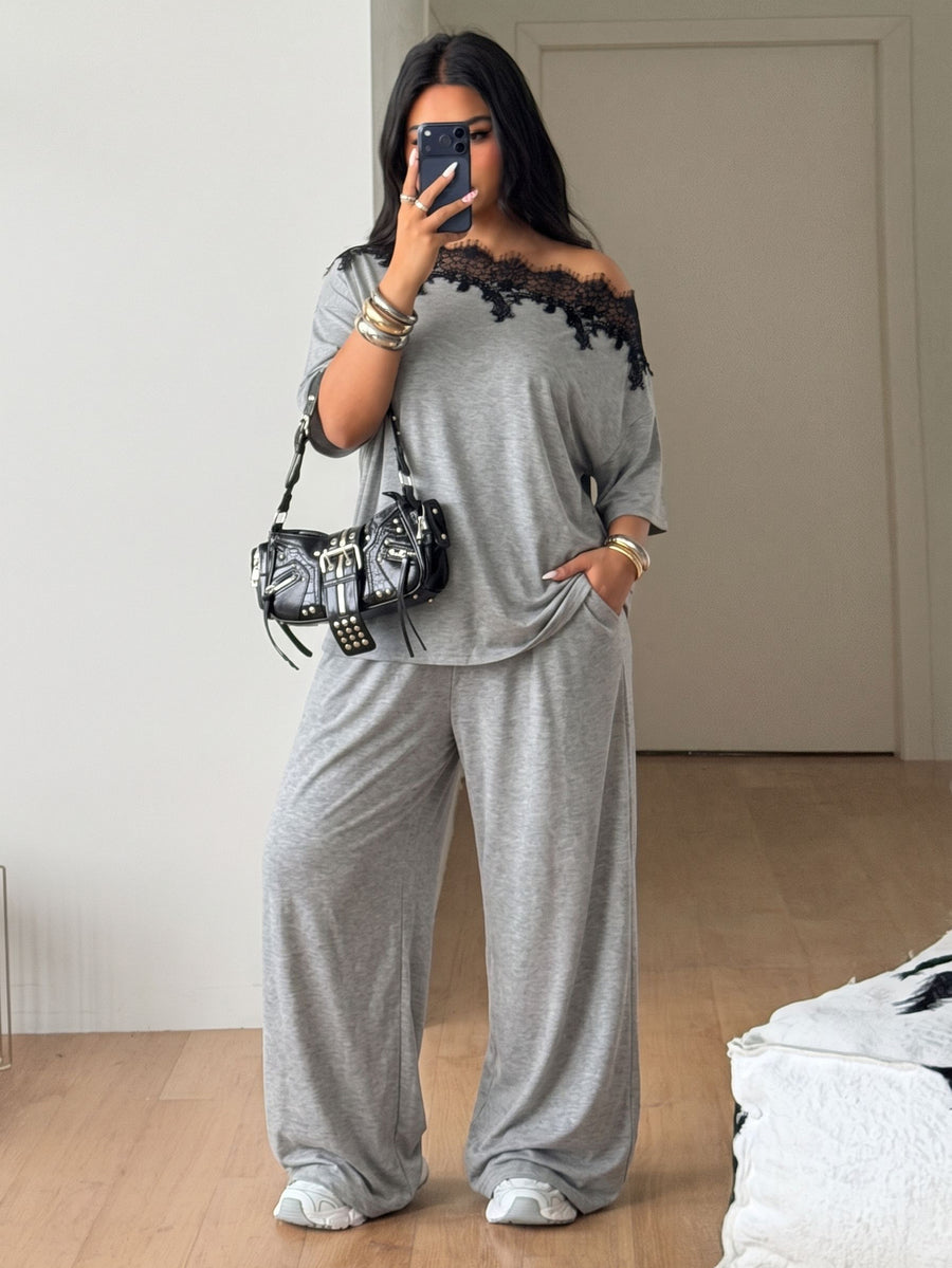Women's casual two-piece outfit featuring a loose short-sleeve asymmetrical neck t-shirt and matching long wide leg pants with pockets.