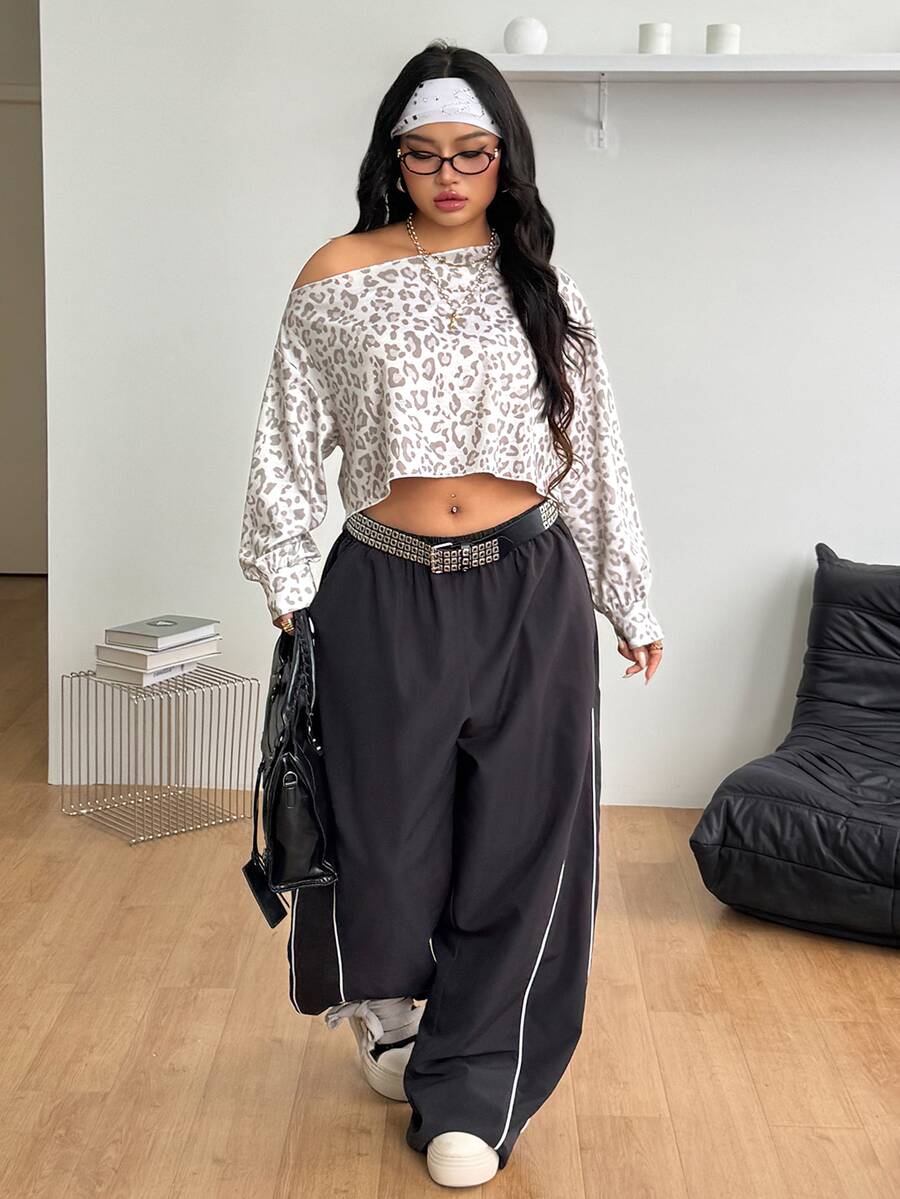 Plus size women's cropped leopard print sweatshirt featuring an asymmetrical neckline and long drop-shoulder sleeves.