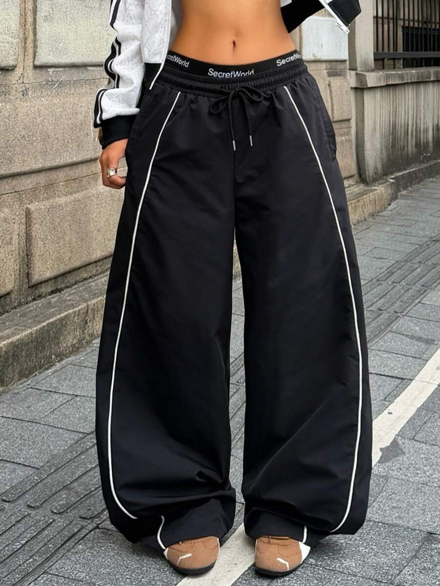 Women's loose fit straight leg pants in black and white with banded texture design, low drawstring waist, and pockets.