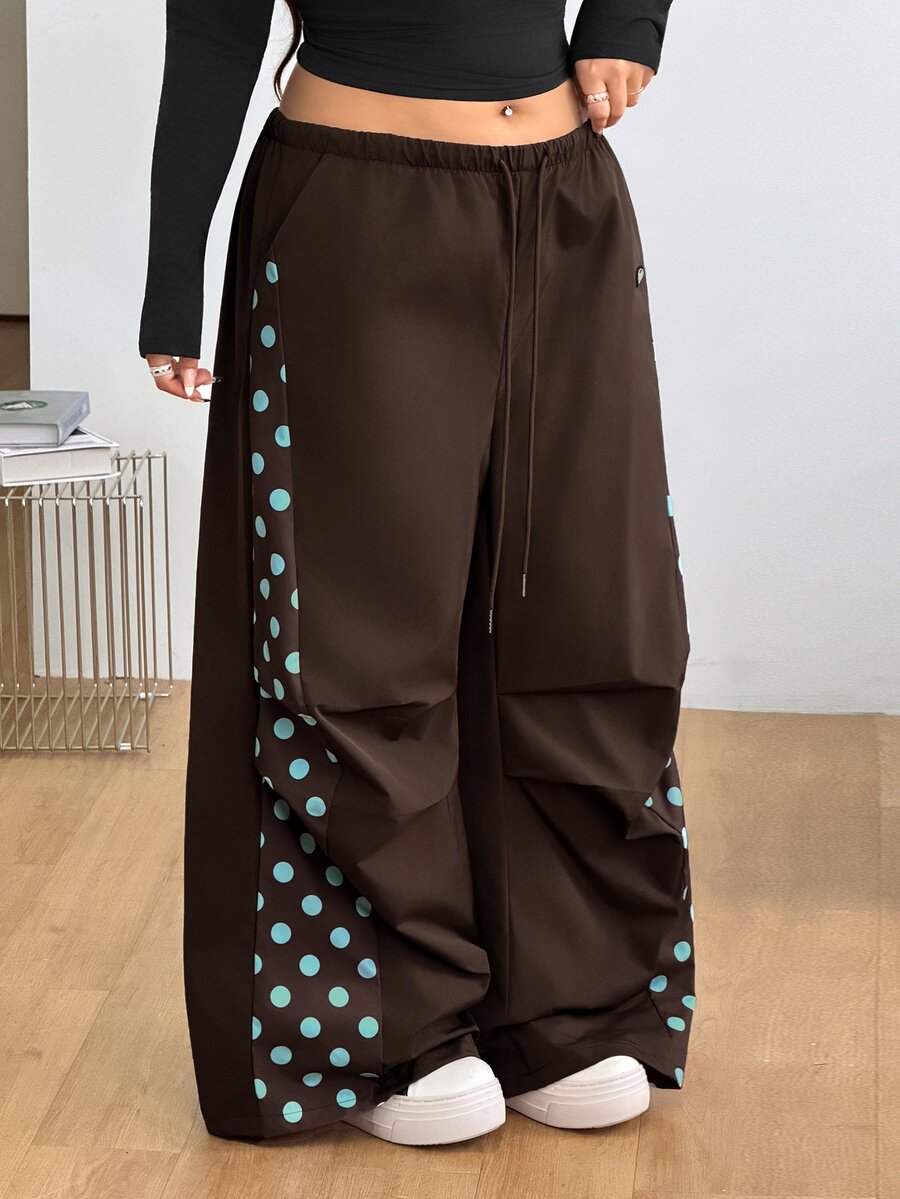 Women's high waist wide leg pants in black featuring leopard print patchwork details and an elastic drawstring waistband.