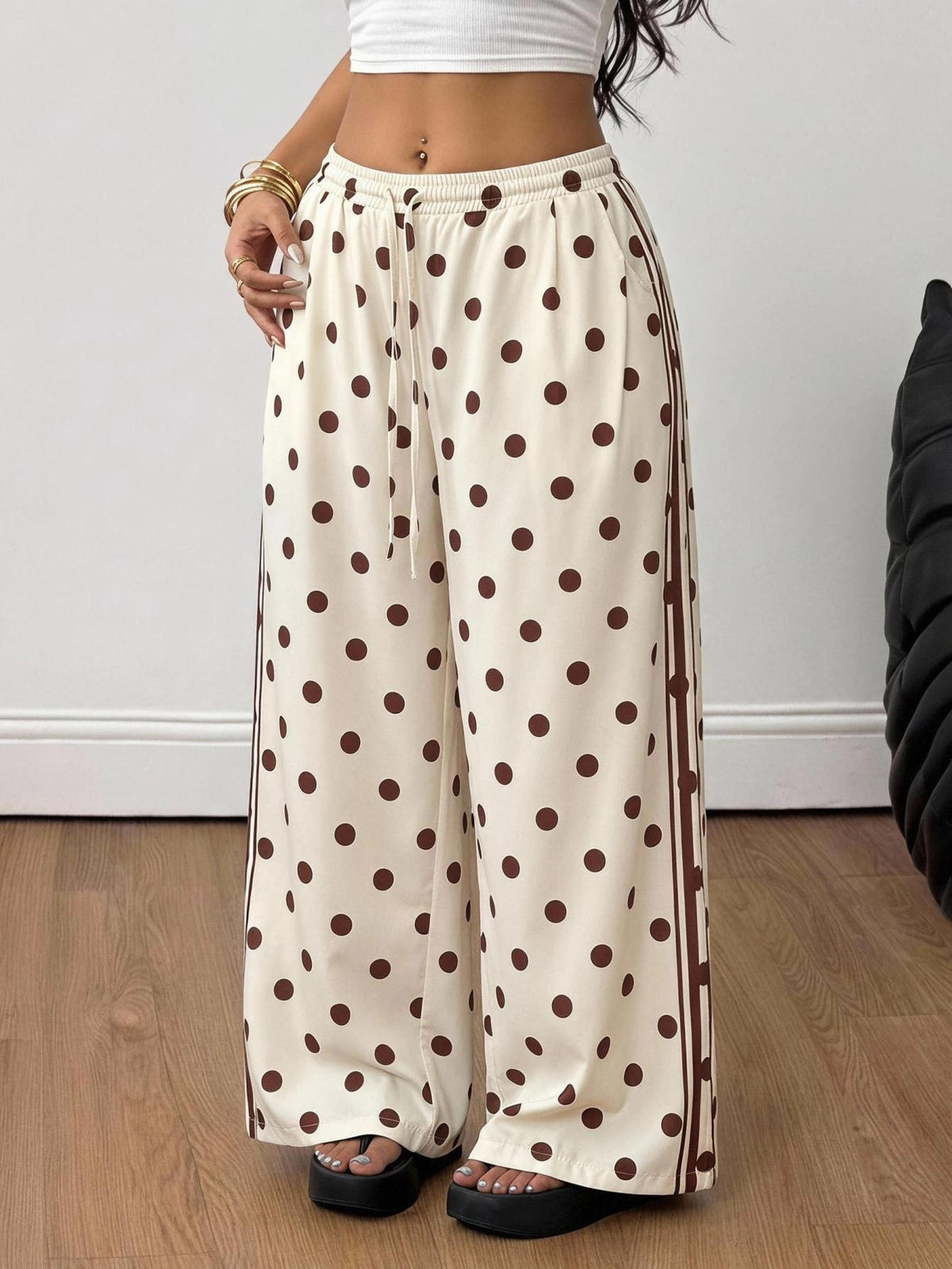 Women's loose straight leg cotton pants featuring a high waist with an adjustable drawstring knot and functional side pockets.