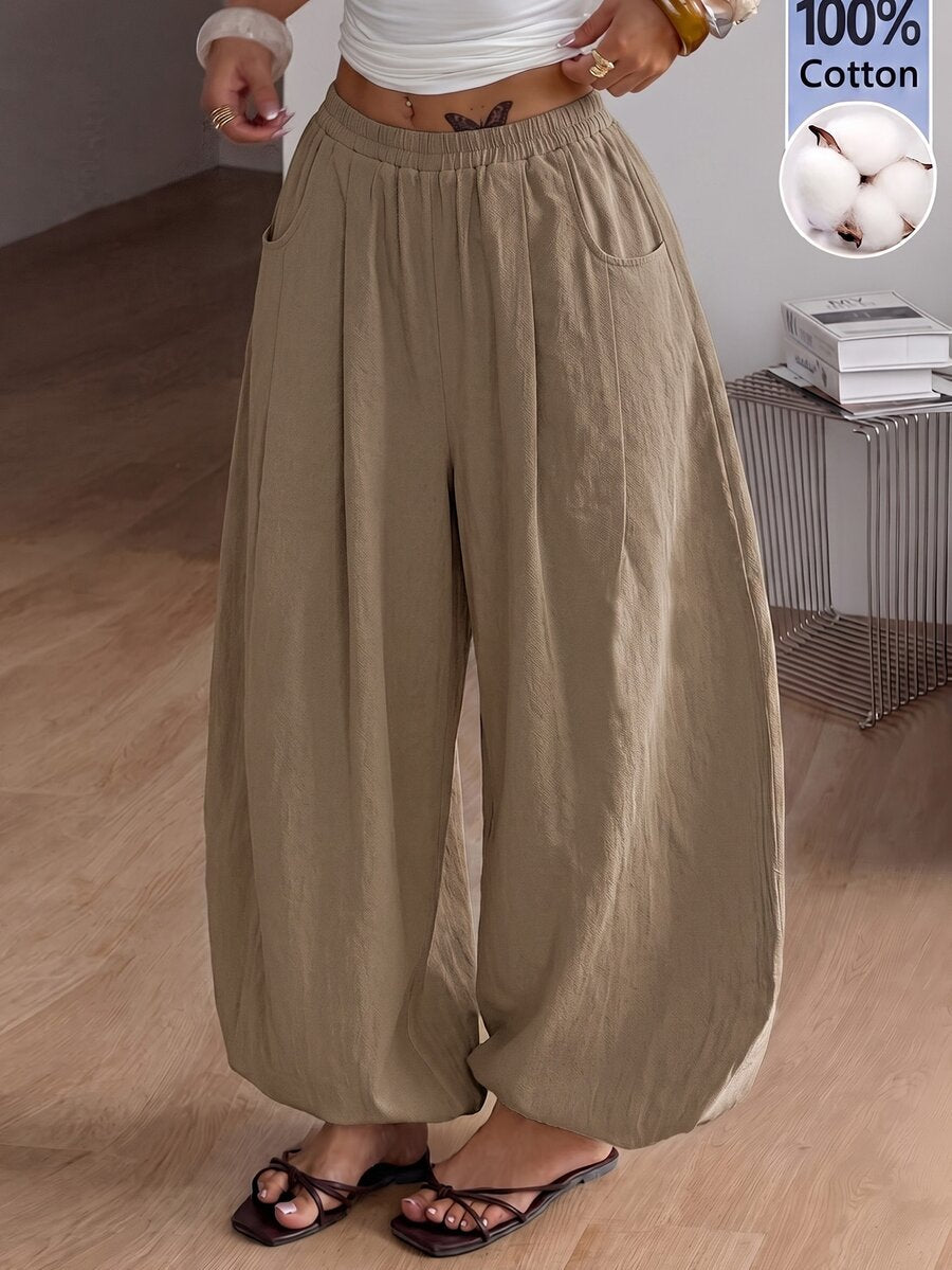 Women's loose-fit black bloomer pants made of 100% cotton featuring an elastic waistband and side pockets.