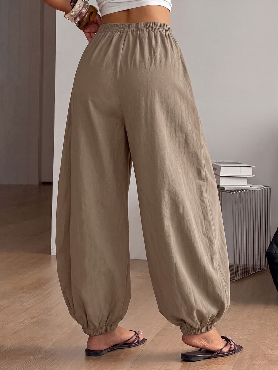 Women's loose-fit black bloomer pants made of 100% cotton featuring an elastic waistband and side pockets.