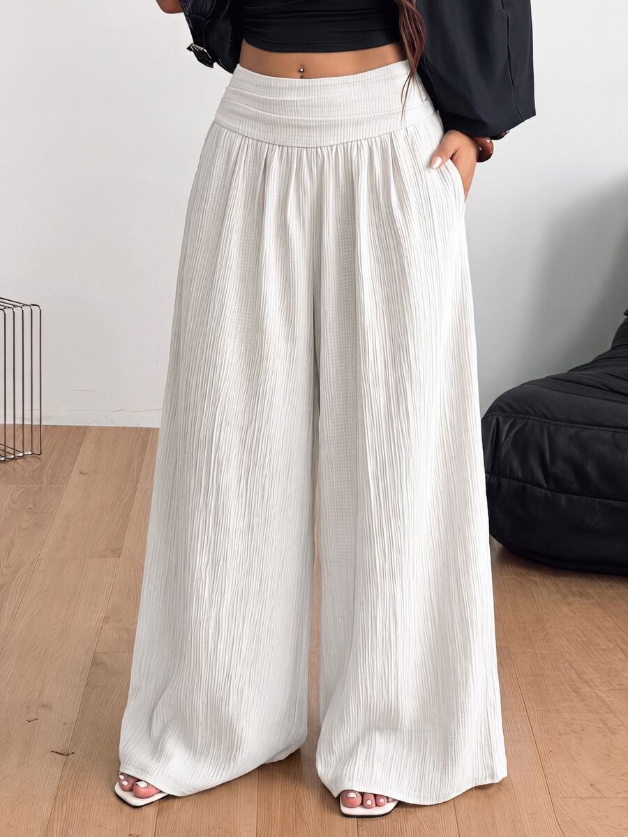 Women's plus size high-waist pleated wide leg pants in textured woven fabric with pockets