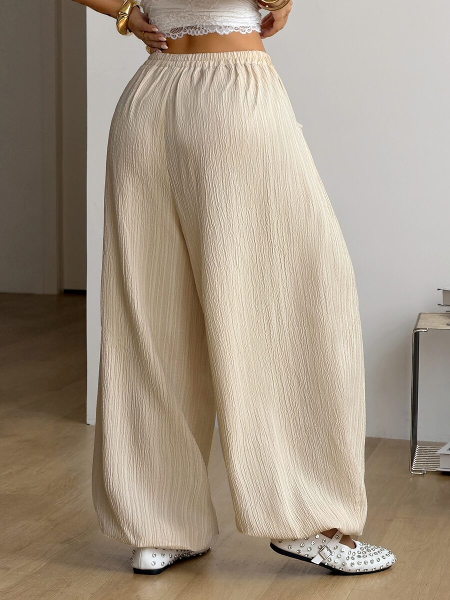 Women's loose-fit black bloomer pants made of 100% cotton featuring an elastic waistband and side pockets.