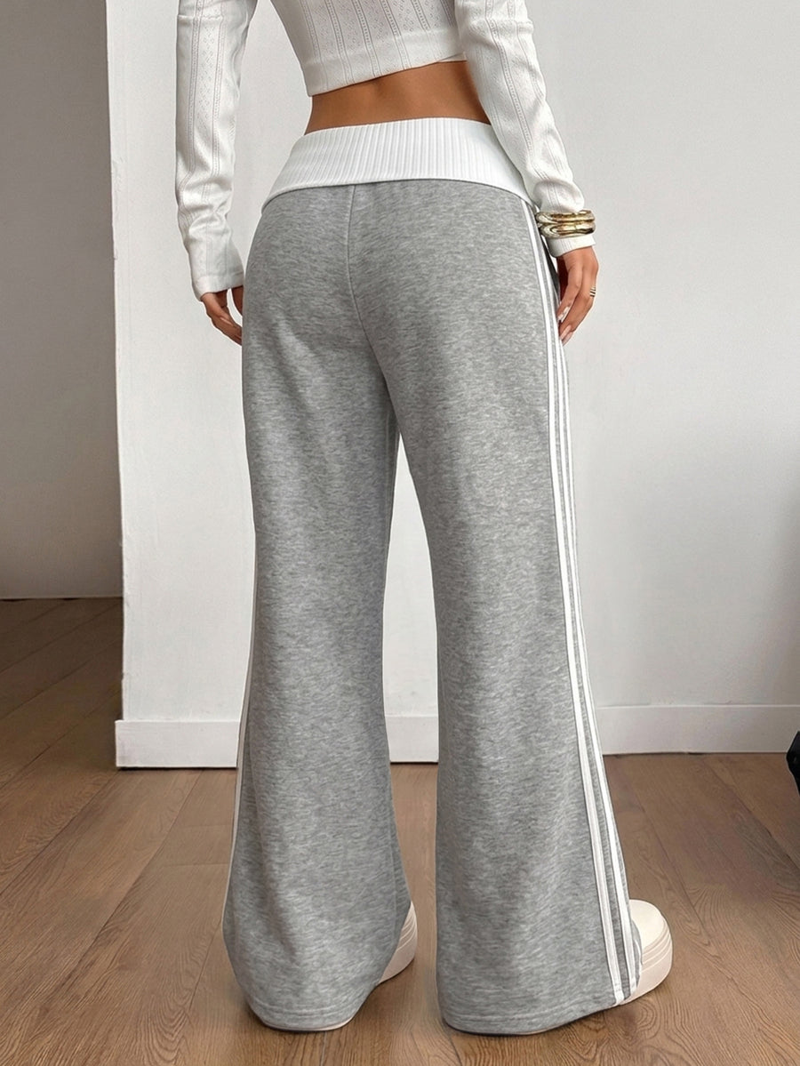 Women's wide leg flare sweatpants featuring a black and white colorblock contrast fold waistband and side stripe details.