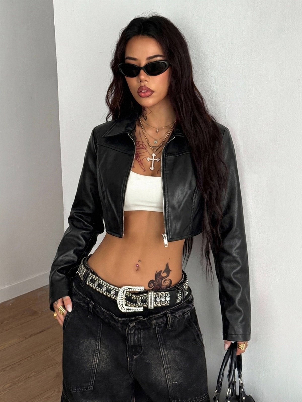 Front view of a women's black cropped PU leather jacket featuring a stand collar, long sleeves, and front zipper closure.