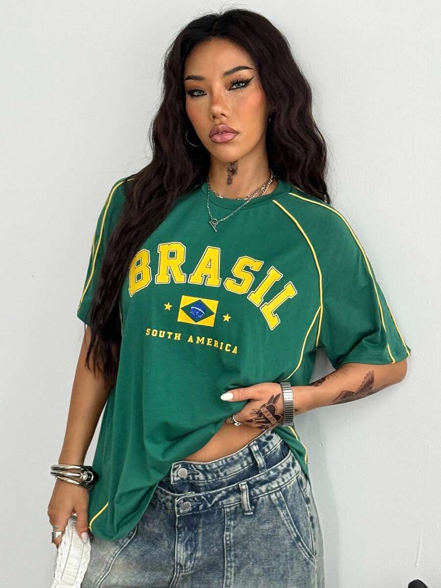Yellow oversized graphic t-shirt featuring Brazil letter print on the front with contrast raglan sleeves and side stripe detailing.