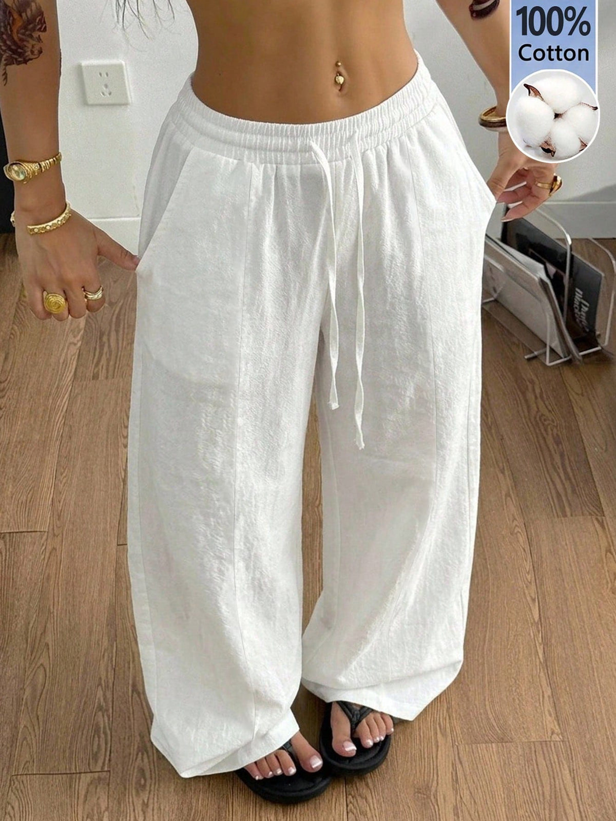 Women's loose straight leg cotton pants featuring a high waist with an adjustable drawstring knot and functional side pockets.