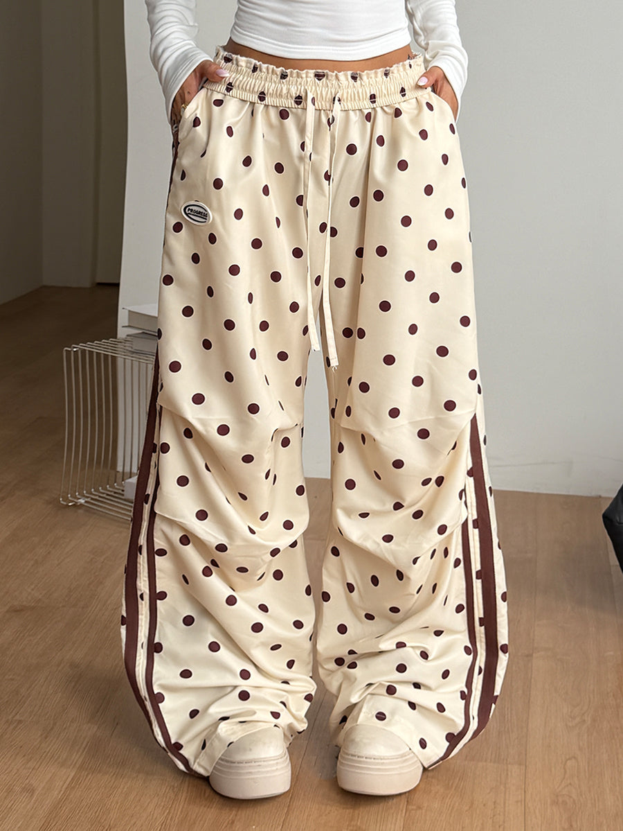 Women's black and white striped wide leg pants featuring an elastic drawstring waistband, side pockets, and a loose straight leg fit.