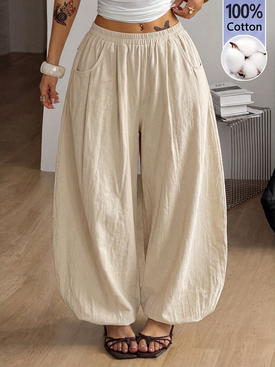 Women's loose-fit black bloomer pants made of 100% cotton featuring an elastic waistband and side pockets.