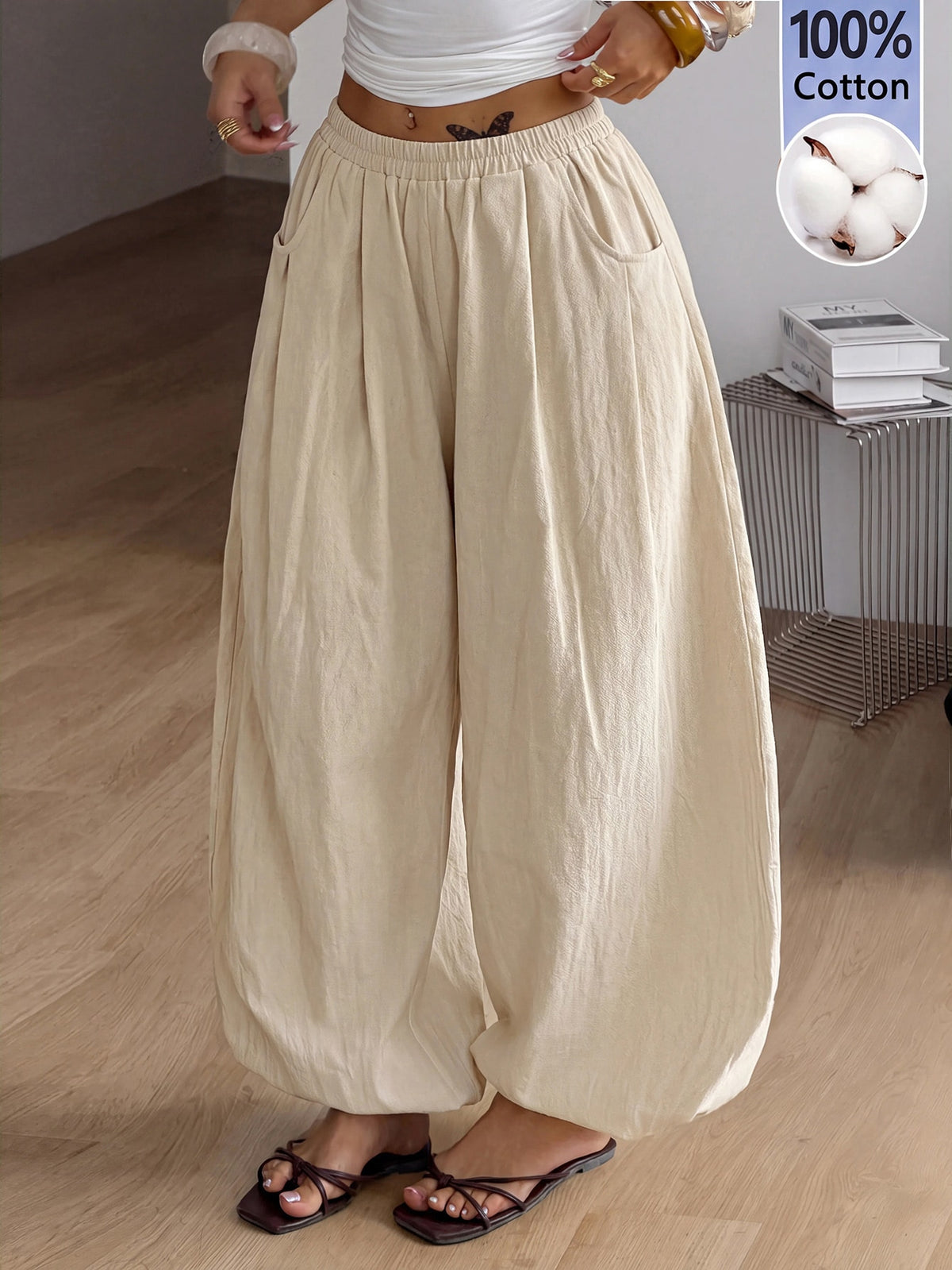 Women's loose-fit black bloomer pants made of 100% cotton featuring an elastic waistband and side pockets.